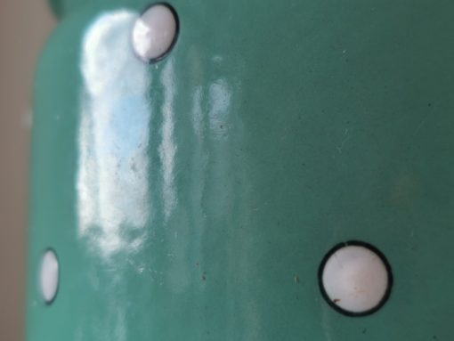 Detailaufnahme weiße Punkte auf grünem Emaille