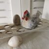 altes Eierregal, dekoriert mit Pappmachée-Huhn und Legeeiern