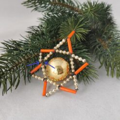 Alter Gablonzer christbaumschmuck in Form eines Stern, hier Fehlstellen markiert mit blauen Pfeilen