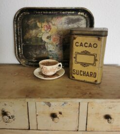 Antike Blechdose Suchard, Rückseite mit geprägtem Schild und Schriftzug Cacao. Dekoriert mit altem Tablett und einer Tasse.