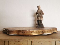 Antikes vergoldetes Podest für Uhren oder andere Kostbarkeiten. Auf dem Podest steht eine antike Staue des heiligen Nepomuk.