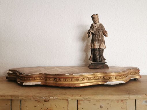 Antikes vergoldetes Podest für Uhren oder andere Kostbarkeiten. Auf dem Podest steht eine antike Staue des heiligen Nepomuk.