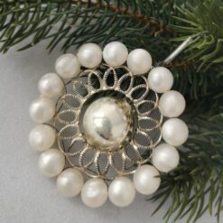 Alter Christbaumschmuck, Nahaufnahme, Kranz aus perlmuttfarbenen Perlen, Metallornament und mittig große silber Kugel