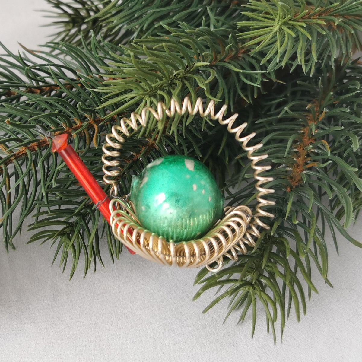 Vintage Christbaumschmuck: Drahtspiralen zu einer Gießkanne geformt, mittig große grüne Perle, Ausgießer rote Stabperle.